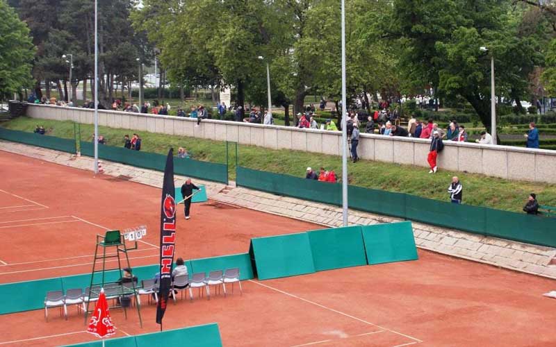 Szemlélődő teniszdrukkerek a Kálóczy téri pályák melletti parkban 